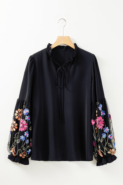 Blouse noire à col fendu et manches volantées à patchs floraux