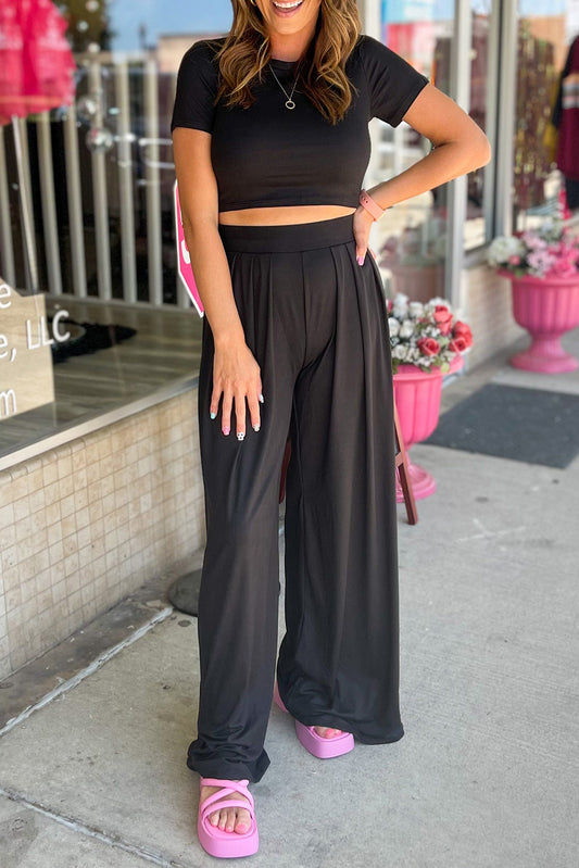 Conjunto de top corto ajustado negro y pantalones anchos plisados