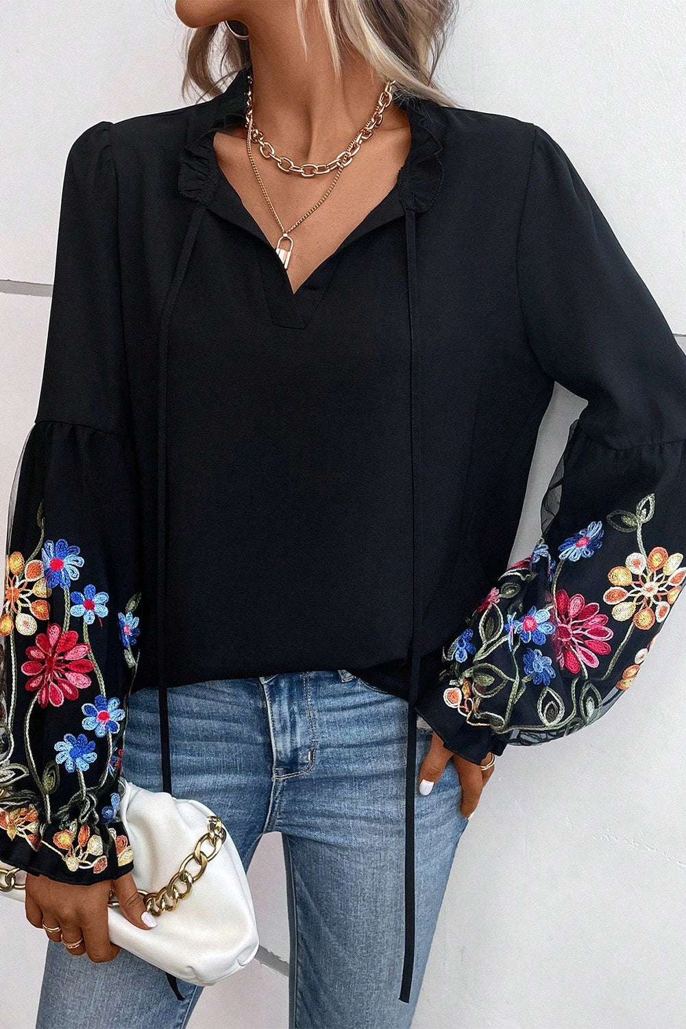 Blouse noire à col fendu et manches volantées à patchs floraux