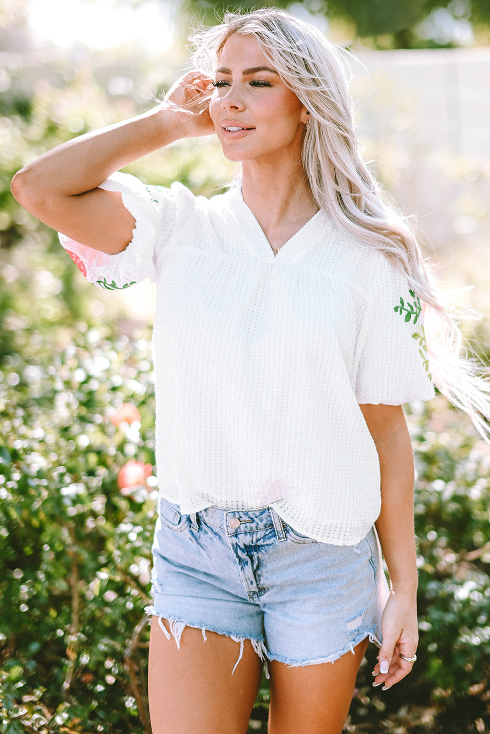 Blouse blanche à col cranté et manches bouffantes brodées de fleurs